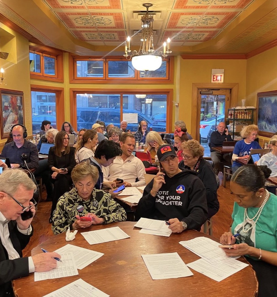 Volunteers making calls to swing-state voters at an in-person phone bank in a Chicago café